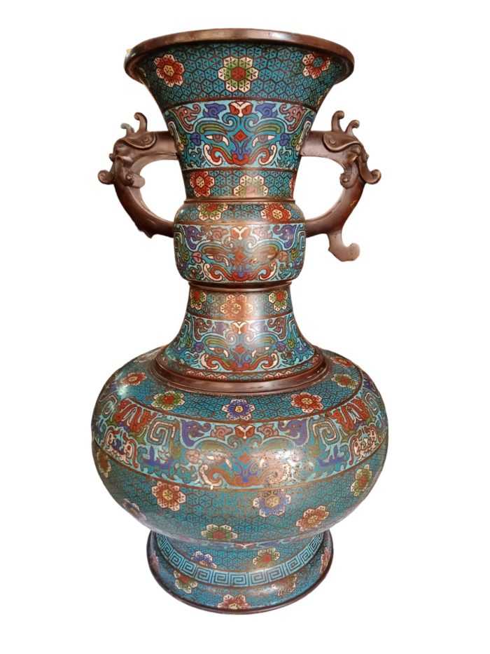 An antique Chinese cloisonne enameled vase. Features and overall octogonal, tapering form, each side embellished with motifs of flowers in vases atop tables. Finished with further cloisonne enameled floral motifs throughout. CIRCA: Late 19th-Early 20th Century.